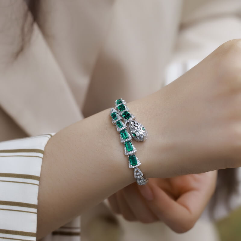 Model with a stylish snake bracelet with lab-created emeralds in her wrist